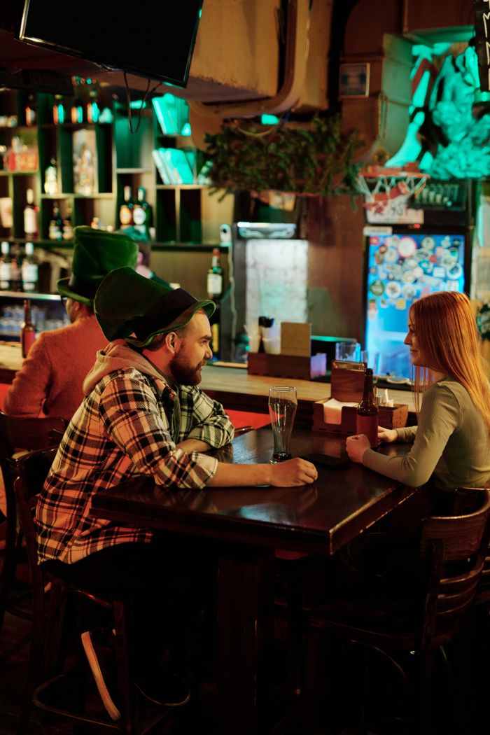Friends enjoying a festive St. Patrick's Day celebration indoors, surrounded by warm ambiance.